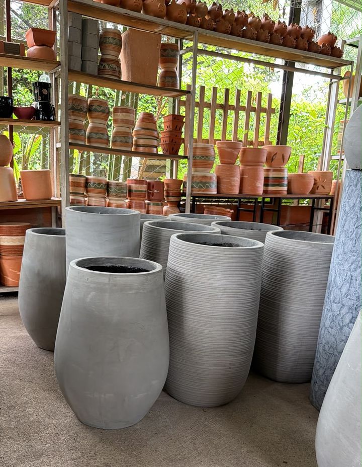 Materas altas de cemento gris frente a estantes con materas de barro